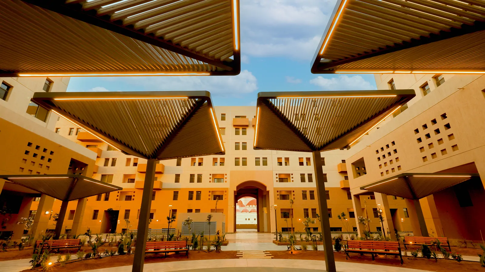 ساحة مظللة بمظلات مضاءة تفضي إلى الجامع